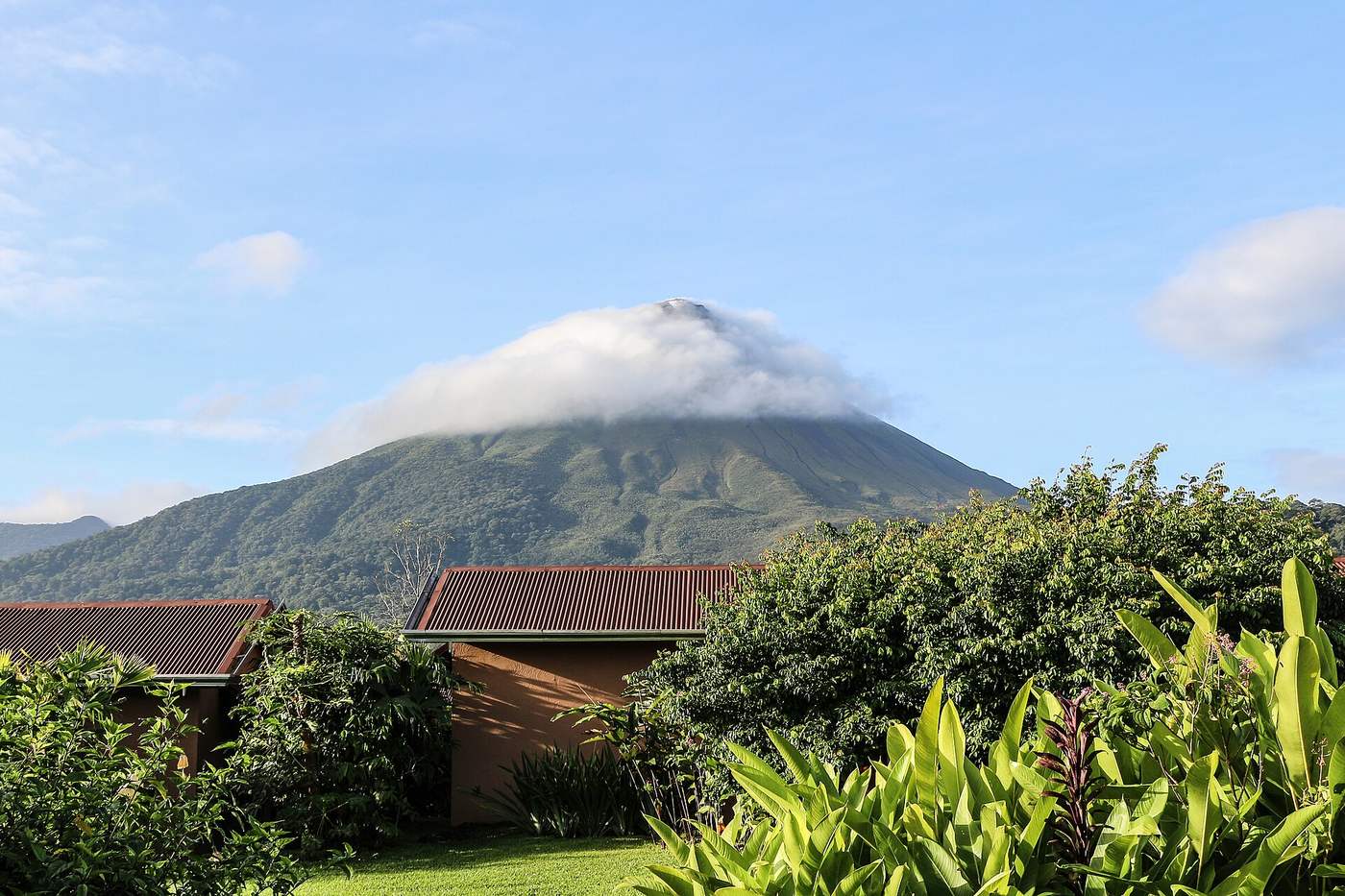 Arenal Volcano rising above garden rooftops near La Fortuna, Costa Rica