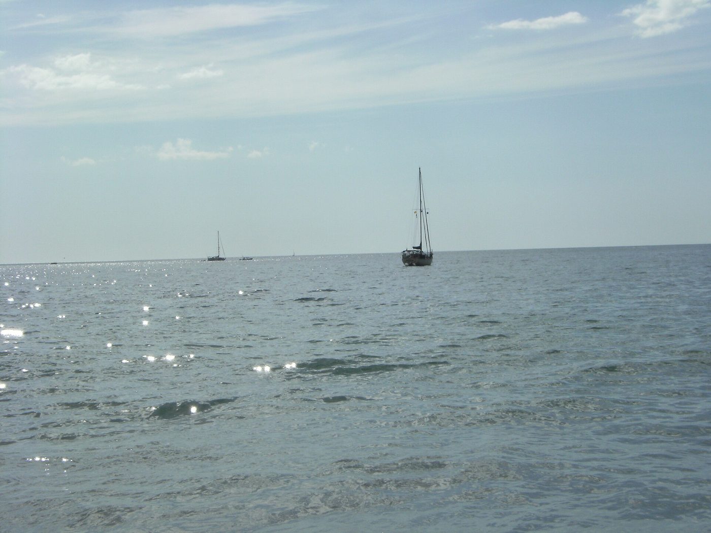 Sailboat off the calm gray sand of Playa Hermosa in Guanacaste, Costa Rica