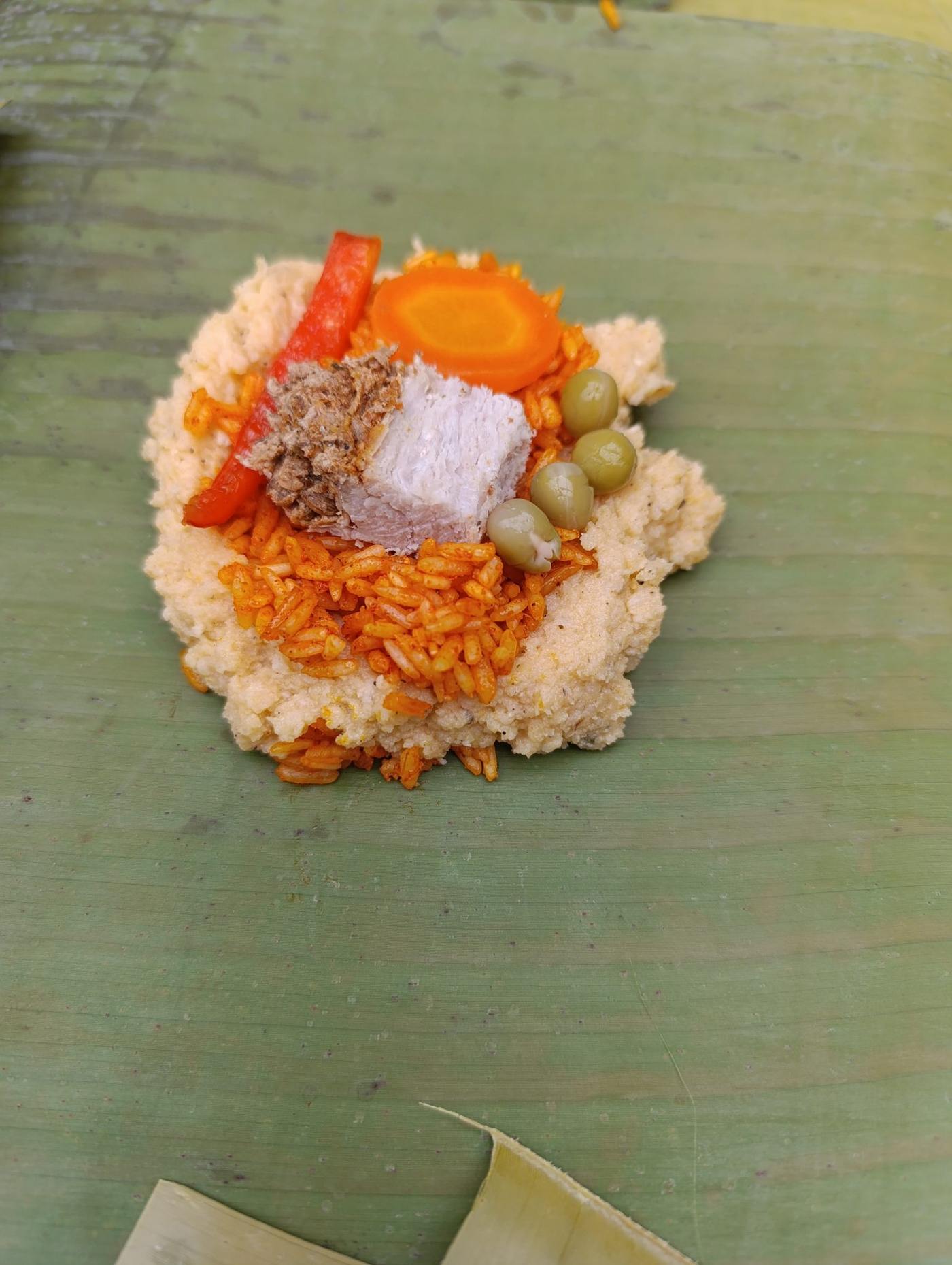 Costa Rican Christmas tamale with masa, rice, pork, and vegetables on a banana leaf