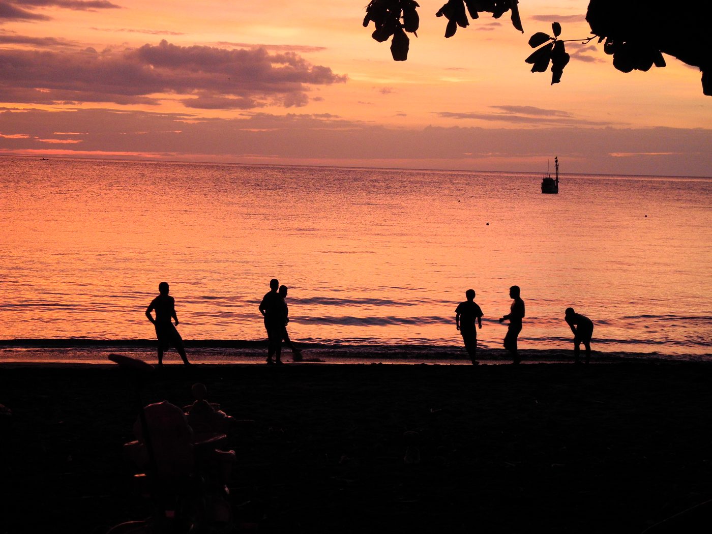 Kids and locals playing pickup soccer on the beach at sunset in Playas del Coco