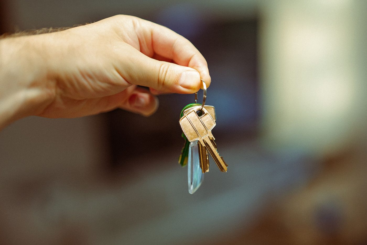Close-up of a hand holding a small ring of house keys