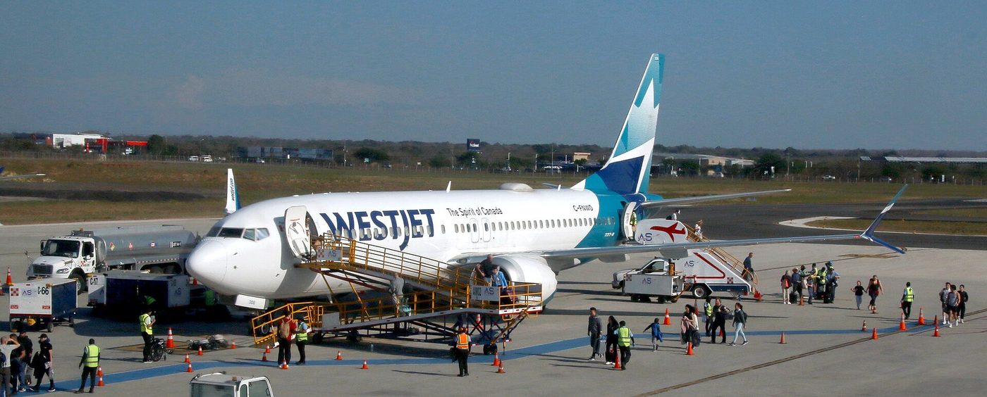 WestJet plane from Canada unloading passengers at Guanacaste Airport in Liberia, Costa Rica