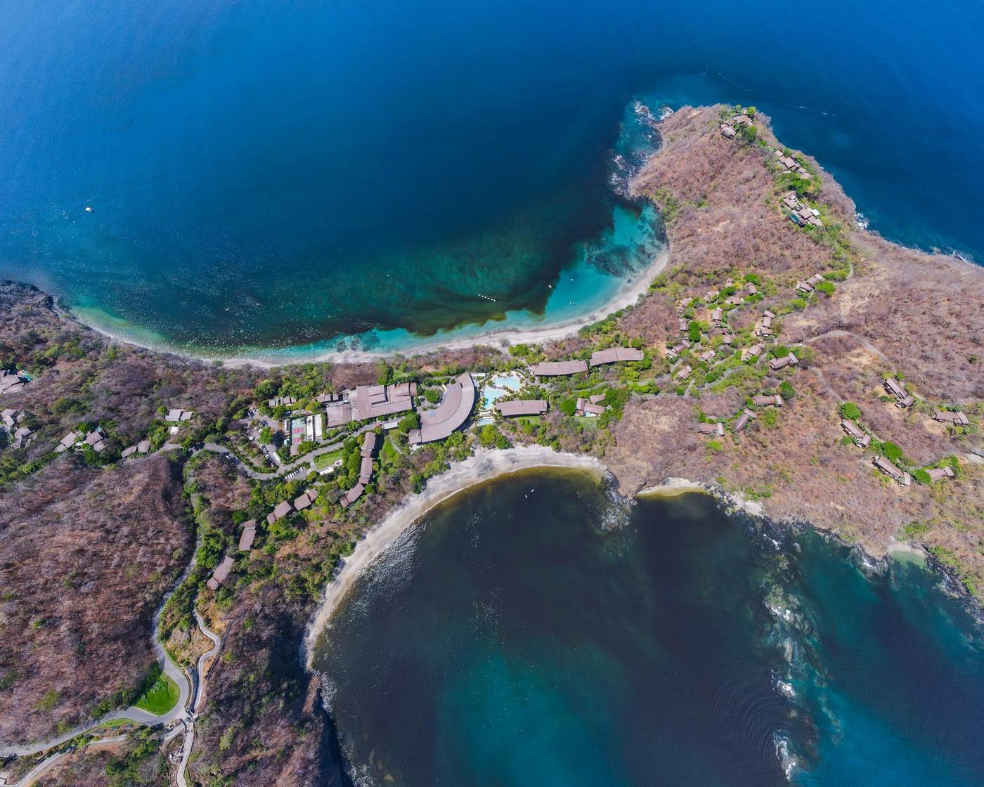 Aerial view of a resort development built into a rocky Guanacaste coastal peninsula