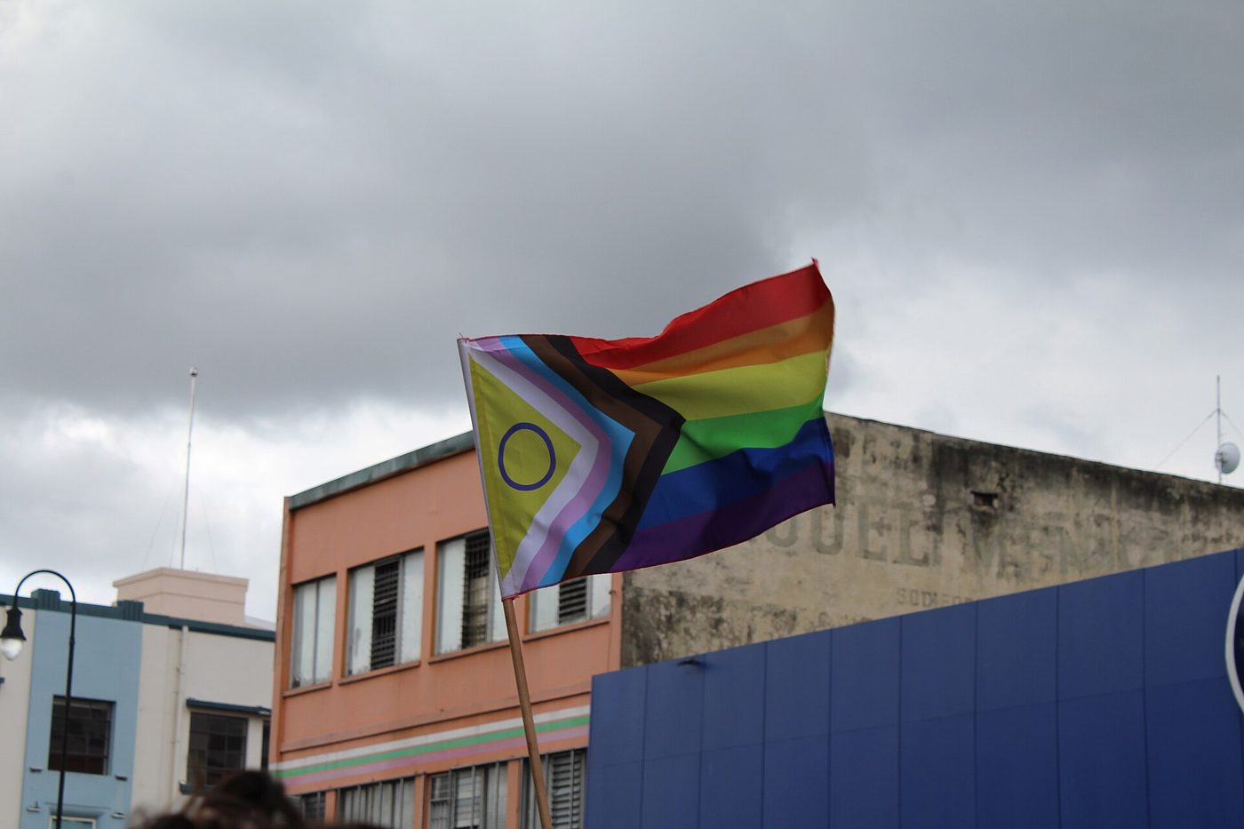 Progress pride flag waving above downtown San Jose buildings during Costa Rica's 2023 Pride march