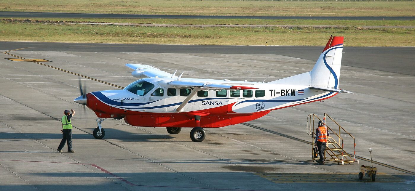 SANSA Grand Caravan turboprop and ground crew on the tarmac at Liberia Airport