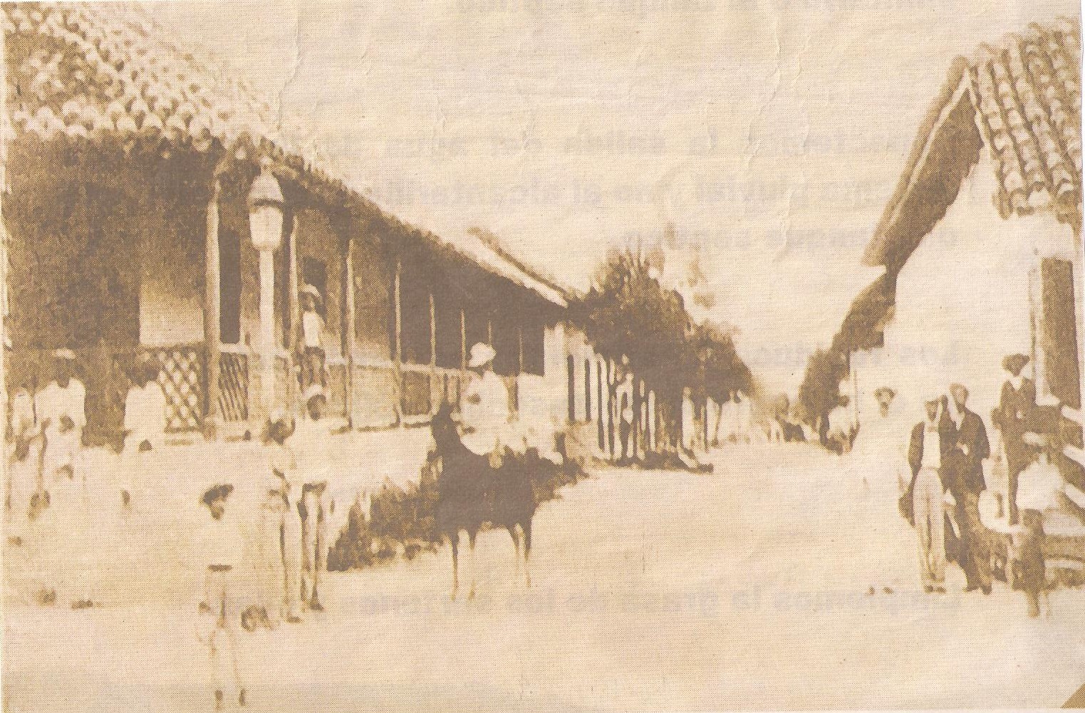 Black and white photo of Calle Real in Liberia, Costa Rica, around 1881, a pale gravel street lined with tile-roofed adobe houses and a man on horseback