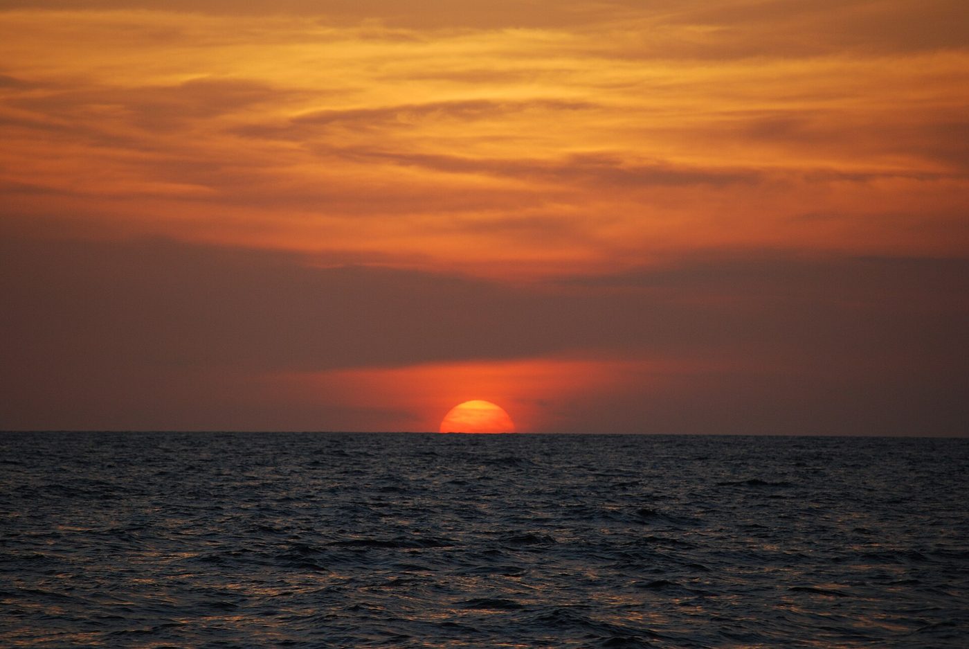Fiery orange Papagayo sunset sinking into the Pacific at Playas del Coco