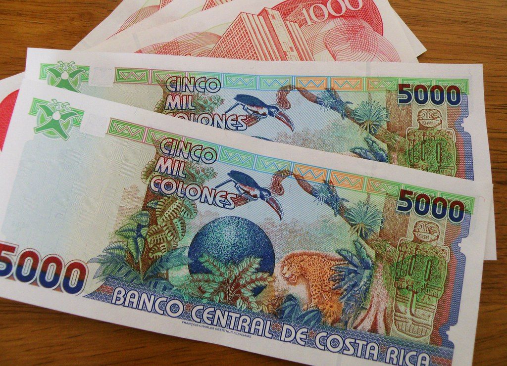 Costa Rican colon banknotes from the Banco Central spread on a wooden table
