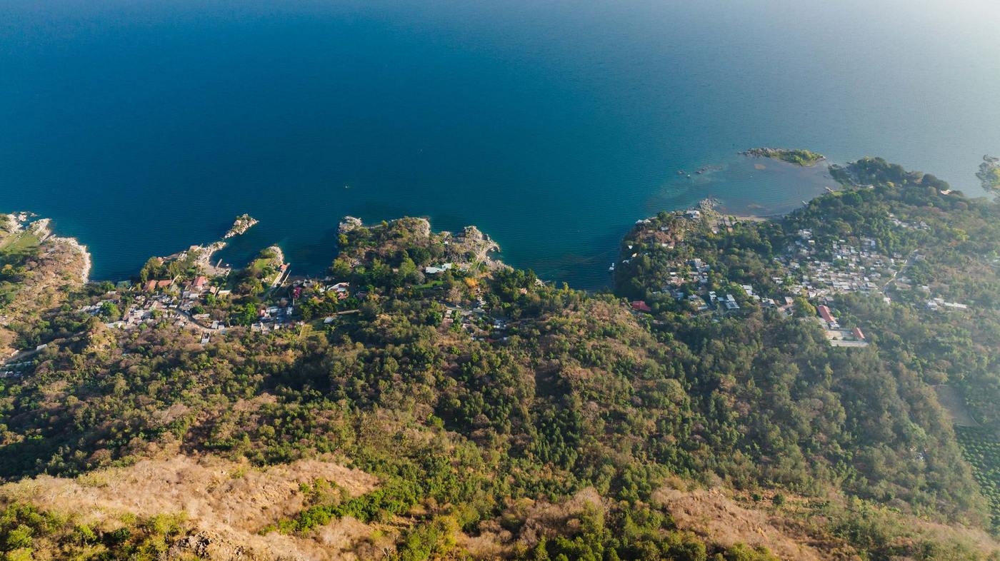 Hillside neighborhoods above a deep blue bay with dry tropical hills