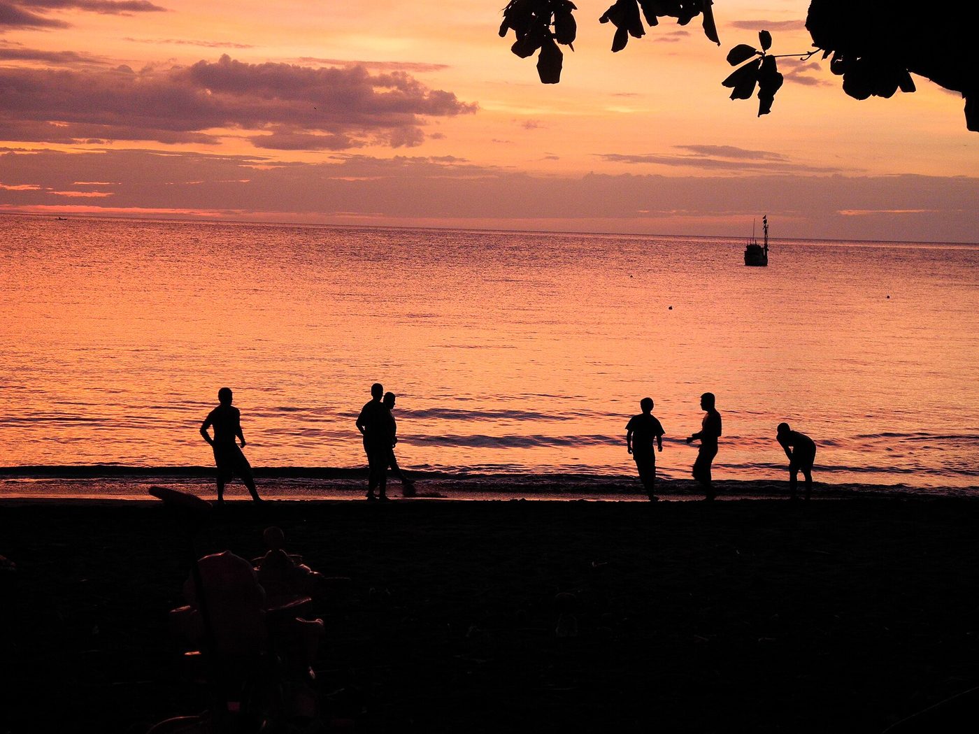 Locals playing soccer at sunset on the dark sand of Playas del Coco