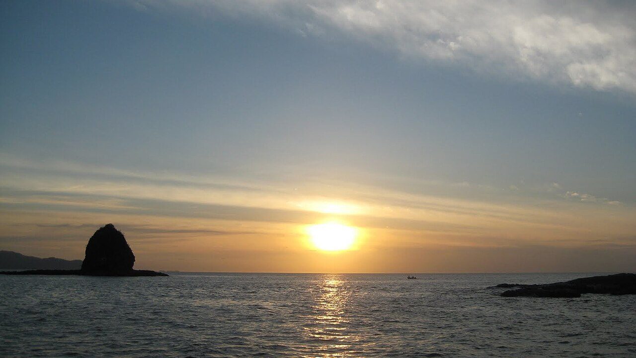Monkey Head rock silhouetted against the setting sun off Playas del Coco