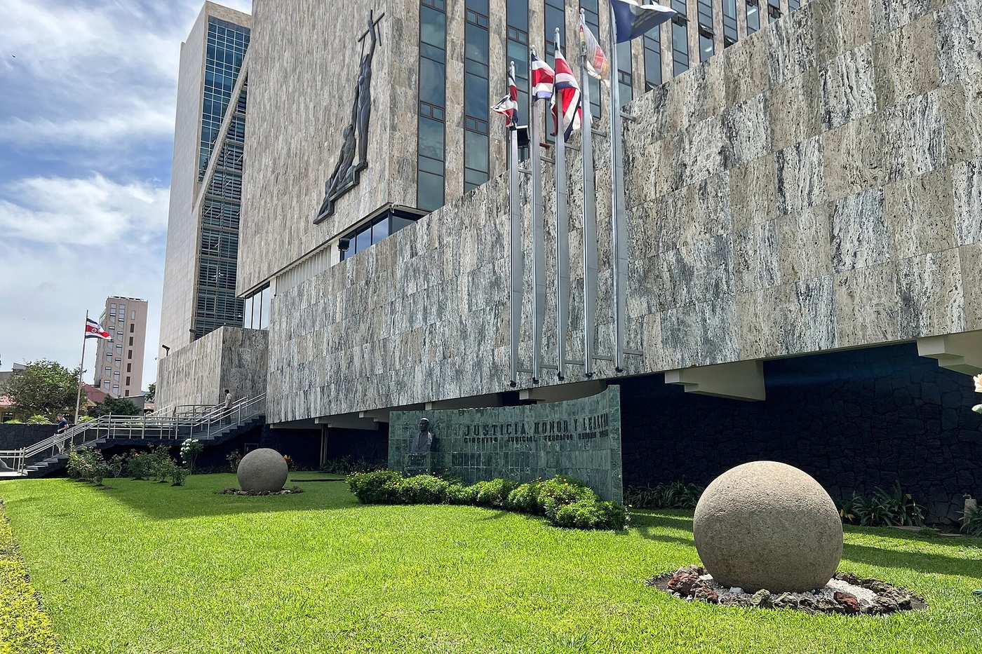 Costa Rica Supreme Court building in San Jose with national flags and Diquis stone spheres