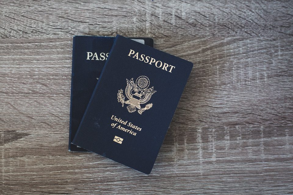Two passports on a wooden table, ready for a residency application