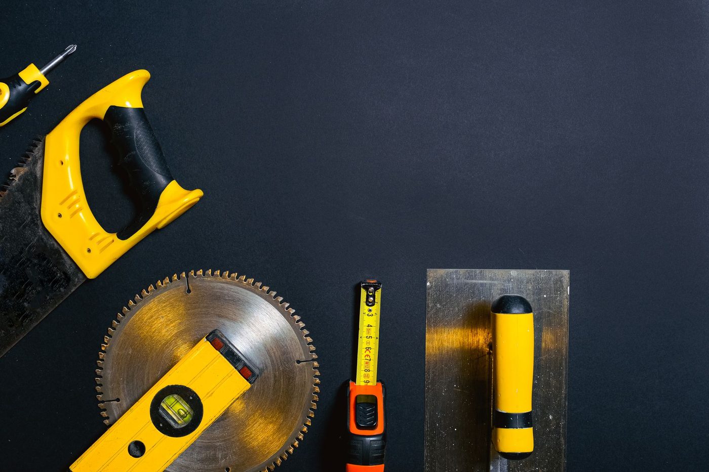 Yellow and black hand tools laid out for property repair and upkeep work