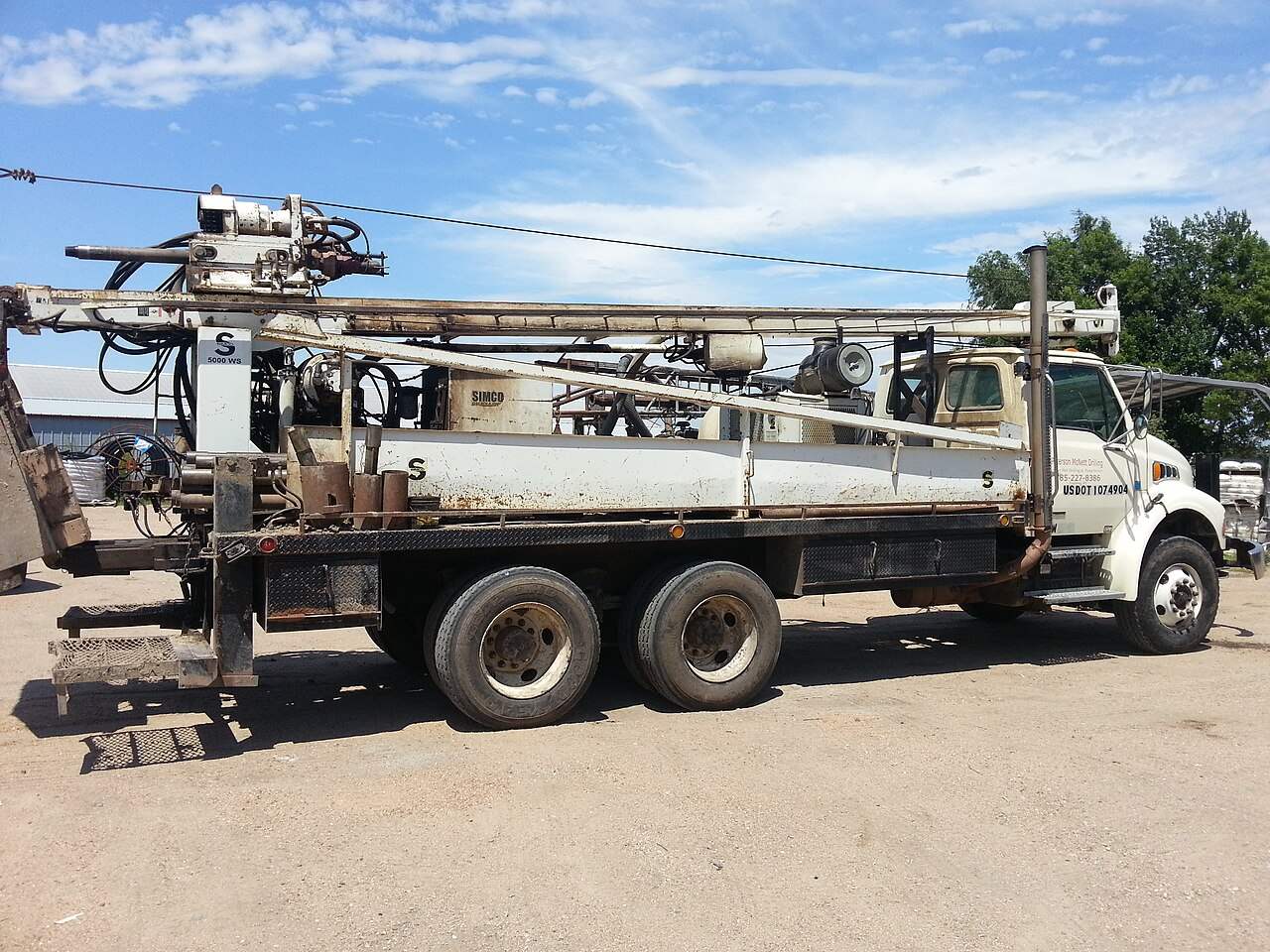 Truck-mounted drilling rig boring a water well, similar to rigs used in Guanacaste