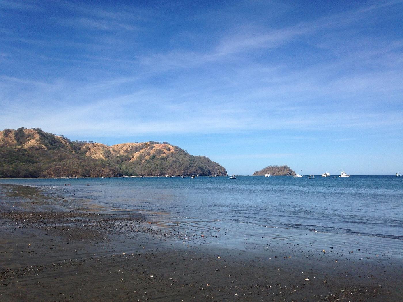 Boats anchored in the calm bay at Playa Hermosa beach in Guanacaste, Costa Rica