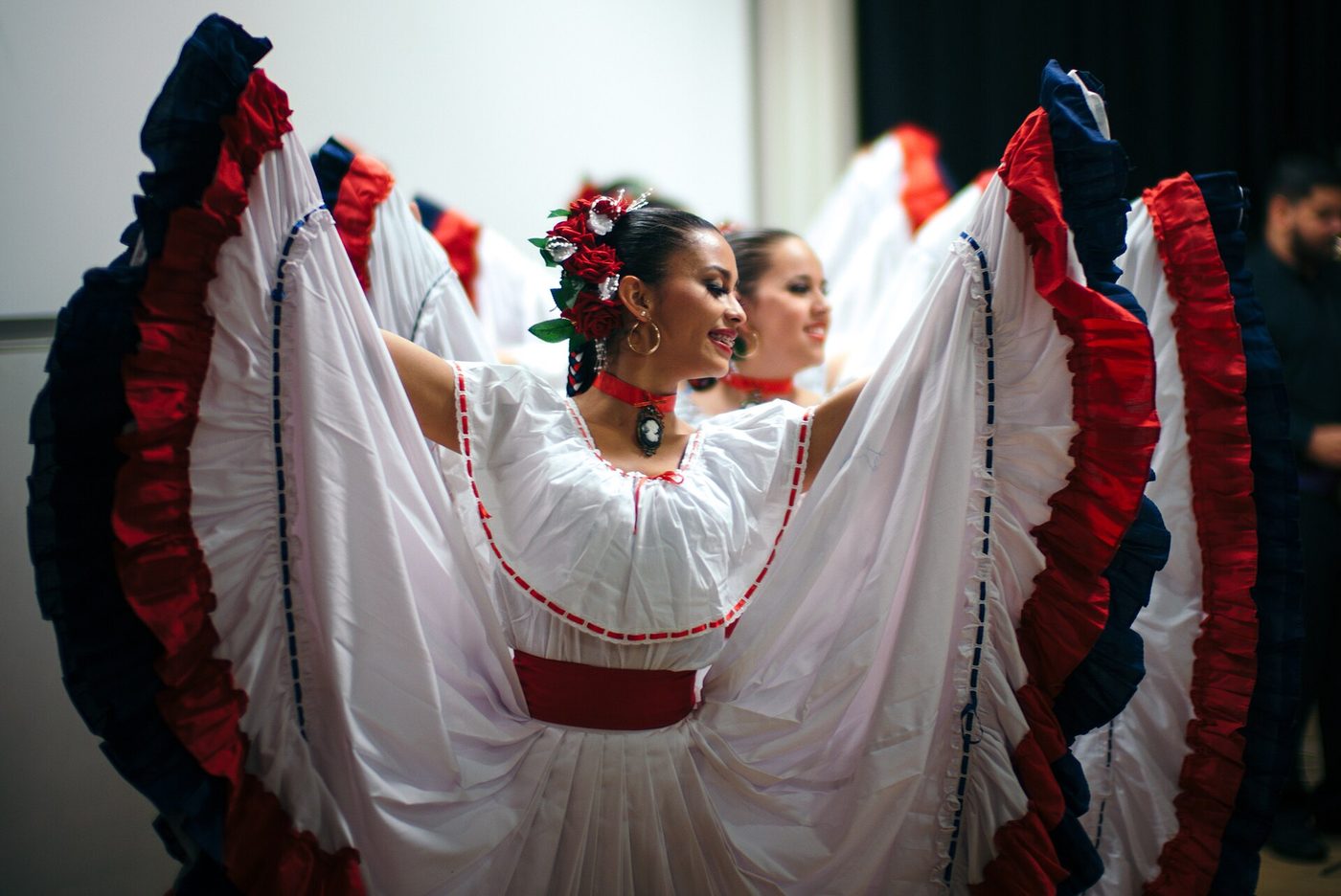 Costa Rican folk dancers swirl white skirts trimmed in red and blue ruffles
